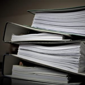 A stack of binders on a desk