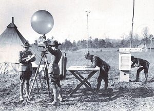 Signal Corpsmen deploy a radio-equipped meteorological balloon in a field